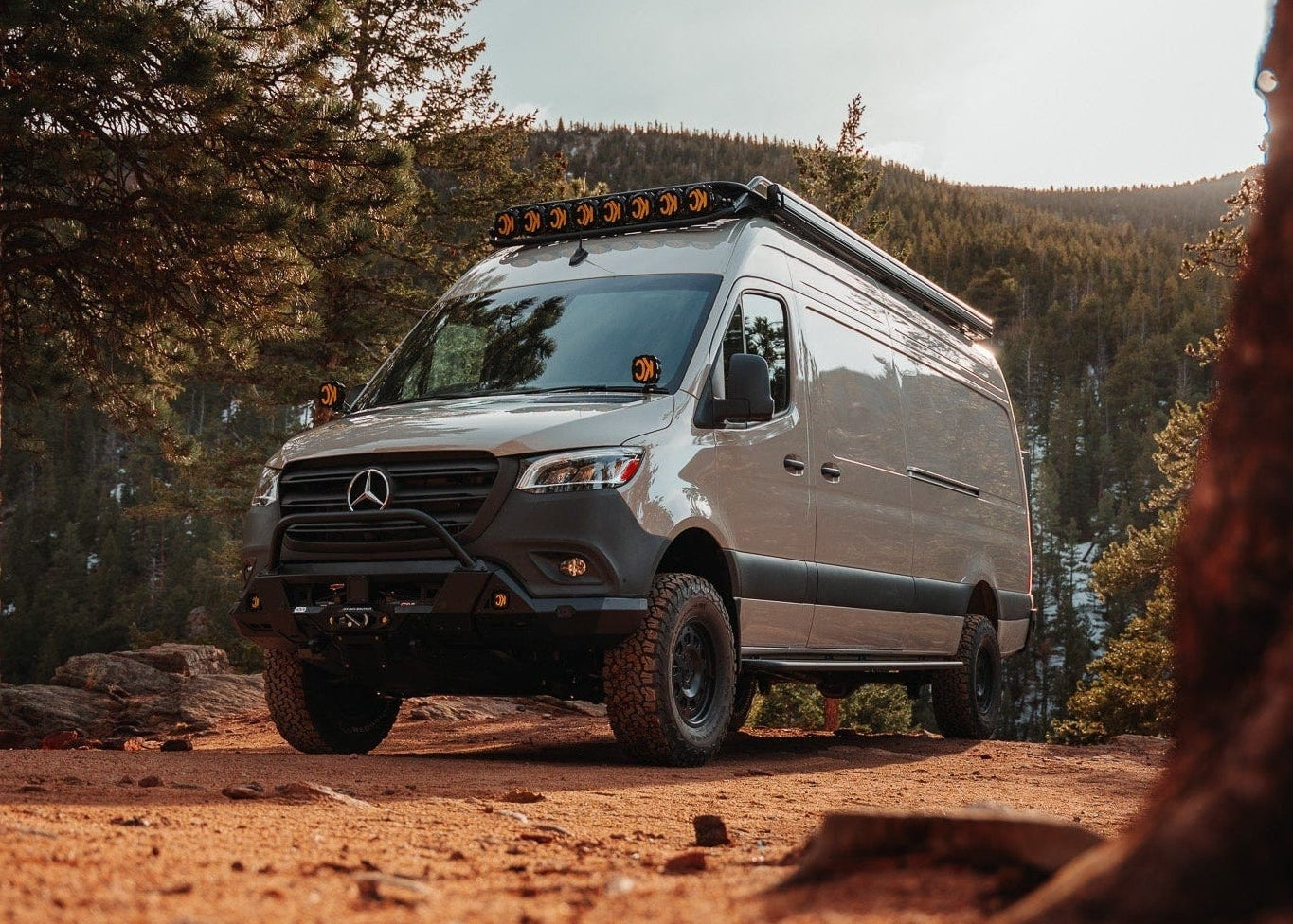 Mercedes Sprinter camper van conversion parked on a forest trail